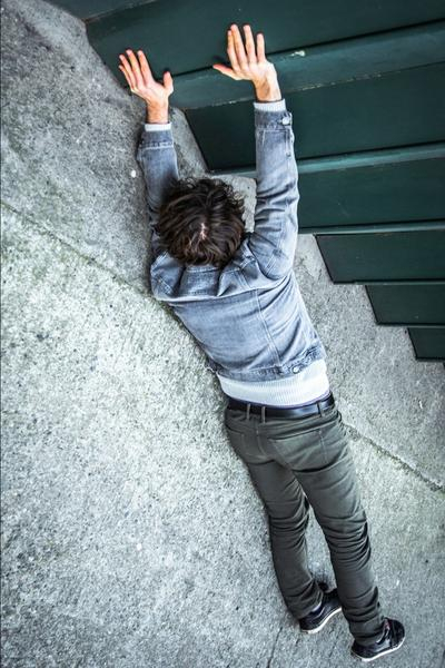 Dasselbe Bild auf dem Kopf: Man sieht, dass der Typ in Wirklichkeit auf dem Boden liegt und Hände an Wellblechkanten legt. Optische Täuschung.